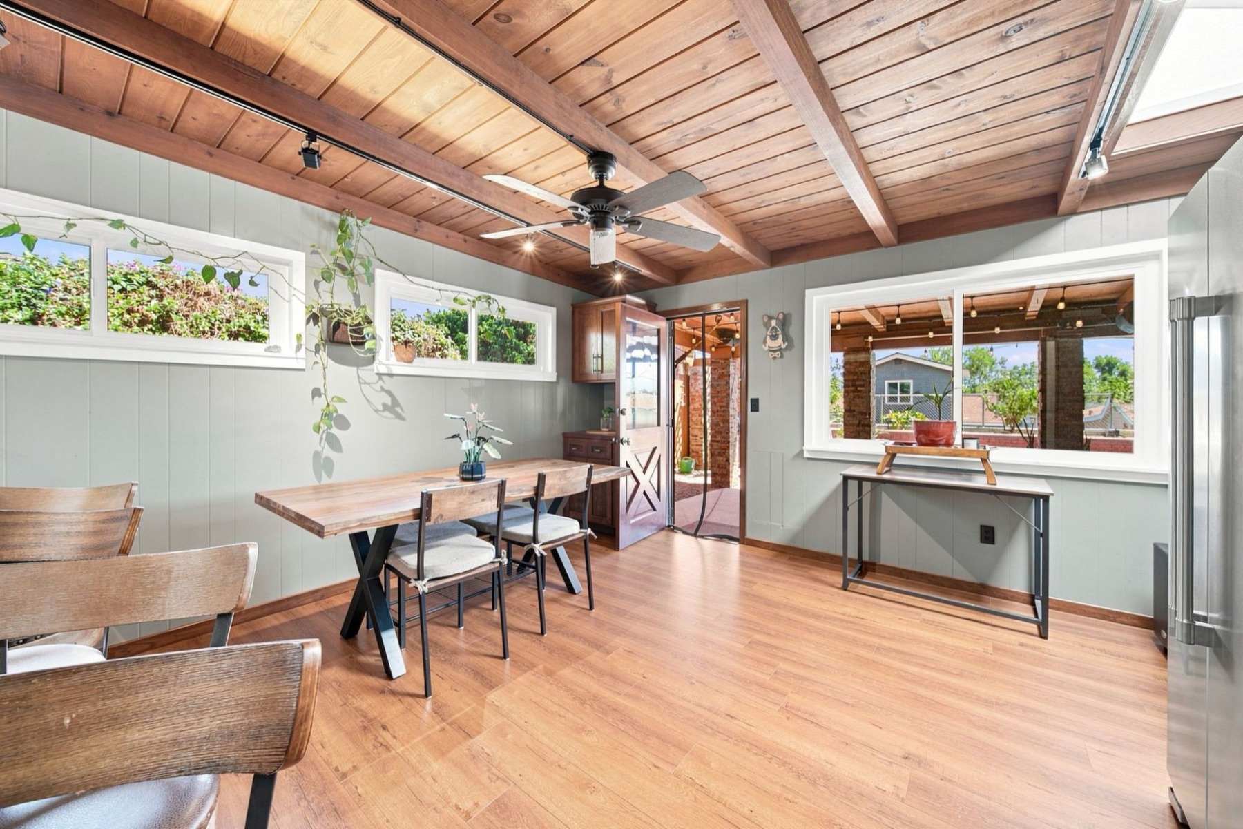 Bright dining room with a wood beam ceiling and garden windows